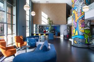 a lobby with a blue couch and orange chairs at Novotel Santiago Las Condes in Santiago