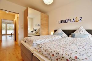 達默的住宿－FeWo "Lütt Möw"，一间卧室配有一张大床和镜子