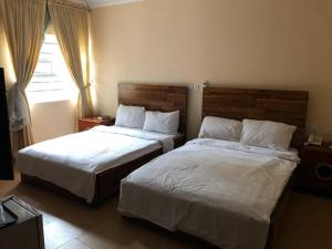 Un pat sau paturi într-o cameră la Conference Hotel and Suites Sagamu
