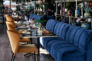 a dining room with blue chairs and a table with food at Hotel Lowietje Lisse - Keukenhof in Lisse