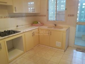 a kitchen with yellow cabinets and a sink at Joli appartement s+2 hammem sousse in Sousse