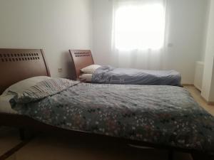 two beds sitting in a room with a window at Joli appartement s+2 hammem sousse in Sousse