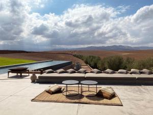 a living room with a couch and a table and chairs at Villa K by Studio KO - Private Luxury Estate Marrakech in Marrakesh
