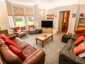 a living room with two leather couches and a coffee table at Muriau Park in Caernarfon