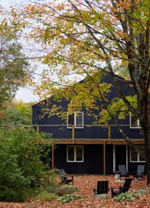 a house with a black facade and trees at Tälta Lodge, a Bluebird by Lark in Stowe