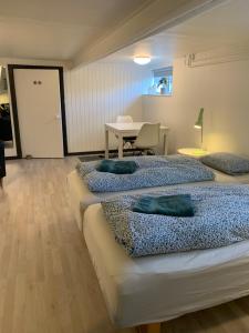 two beds in a room with a table and a desk at H. C. Lumbyes Vej - kælderlejlighed in Odense