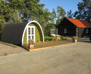 Casa pequeña con terraza y mesa en Recreatieboerderij Hoeve Noordveld, en Oude Bildtzijl