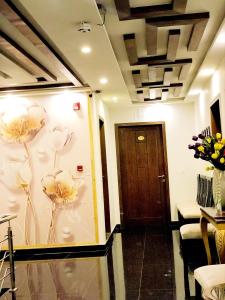 Jade Dragon Hotel DHA Lahore في لاهور: غرفة بها زهور مرسومة على الحائط