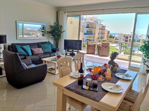 een woonkamer met een tafel en een bank bij AlbufeiraOrada SunSet Penthouse by Be Cherish in Albufeira