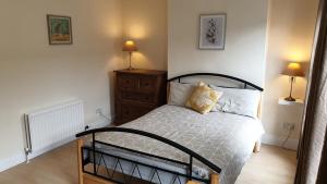um quarto com uma cama, uma cómoda e 2 candeeiros em Private Home Titanic History em Belfast