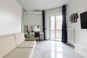 a living room with a white couch and a table at BnButler - Largo Promessi Sposi - Moderno e Confortevole in Milan