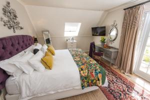 a bedroom with a large bed with yellow pillows at Baruch Guest House in Stellenbosch