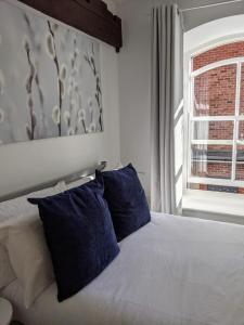 um quarto com uma cama com almofadas azuis e uma janela em Riverside Apartment York em York