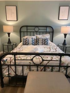 a bedroom with a black metal bed with two lamps at HHI Homes- Newly Renovated Cozy Modern Pet-Friendly Villa-Ideal Location in Hilton Head Island