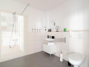 La salle de bains blanche est pourvue de toilettes et d'un lavabo. dans l'établissement limehome Berlin Neue Straße, à Berlin