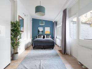 1 dormitorio con cama y pared azul en limehome Berlin Neue Straße, en Berlín