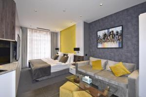 a living room with a bed and a couch at Avenue ApartHotel in Yerevan