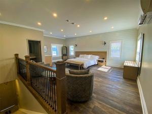 a large bedroom with a bed and a staircase at Colonial Hotel & Suites in Grand Bend