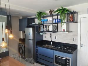 巴拉奈里奧－坎布里烏的住宿－Lindo apto tudo novinho, prédio frente mar，厨房配有蓝色橱柜和冰箱。