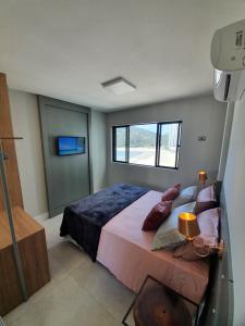 une chambre avec un grand lit avec une fenêtre dans l'établissement Lindo apto tudo novinho, prédio frente mar, à Balneário Camboriú