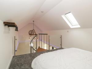 an attic bedroom with a bed and a skylight at Littlemoor Cottage in Cheddar