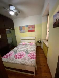 Un dormitorio con una cama con flores rosas. en Un tocco provenzale a Savigliano, en Savigliano