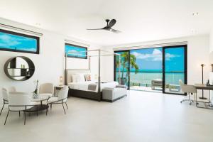 a bedroom with a bed and a table and chairs at Paradiso Del Mar, Turtle Tail, TCI in Turtle Cove