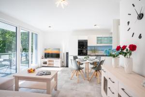 a living room with a table and chairs and a kitchen at Apartment "Haffblick" - Haffresidenz in Garz