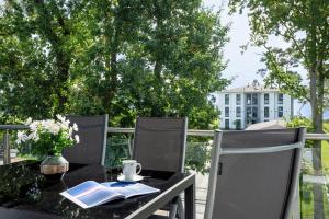 a table with books and a cup on a balcony at Apartment "Haffblick" - Haffresidenz in Garz