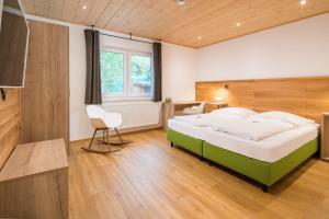 ツィルンドルフにあるHatzels Häuschenのベッドルーム(緑と白のベッド1台、椅子付)