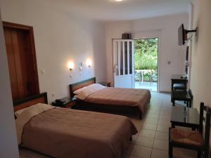 a hotel room with two beds and a balcony at Kyriaki Hotel in Kato Daratso