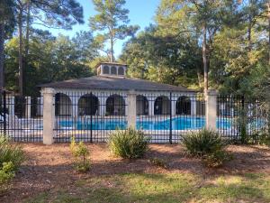 a building with a swimming pool behind a fence at HHI Homes LLC in Hilton Head Island