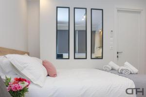a bedroom with a white bed with four windows at New deluxe studio 4 downtown Thessaloniki- Fully equiped in Thessaloniki