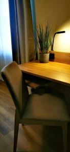 a chair sitting next to a wooden desk with a plant at Atelier Hotel Essen-City in Essen