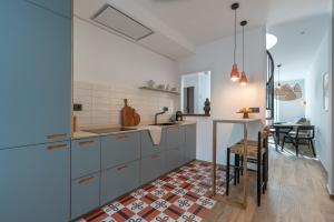 uma cozinha com armários azuis, uma mesa e uma sala de jantar em Attic Oasis em Málaga