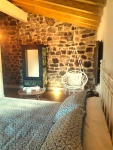 a bedroom with a bed and a stone wall at LA POSADA DEL TENOR in Molledo