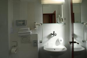 Baño blanco con lavabo y espejo en Unitas Residence en Praga