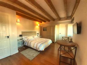 a bedroom with a bed and a table in it at LA POSADA DEL TENOR in Molledo