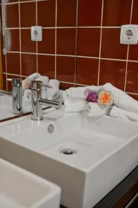 ein Waschbecken mit Handtüchern und eine Blume darauf in der Unterkunft Hotel Vila Luena in Vila Verde