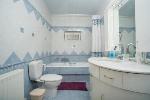 łazienka z toaletą, umywalką i wanną w obiekcie Olive Green Suite w mieście Ligaria +37 zdjęć