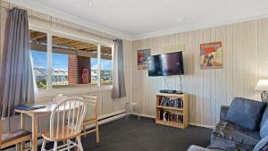 a living room with a table and a couch and a television at Montauk Oceanside Suites in Montauk