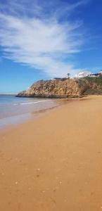 una playa de arena con una isla en el agua en Terrace apartament on the Sea, en Albufeira