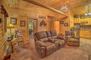 a living room with a couch and a chair in a cabin at Updated Manistique Log Cabin, Yard and Fire Pit in Manistique