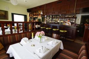 ein Esszimmer mit einem Tisch und einer Bar in der Unterkunft Hotel Spreeblick in Lübben
