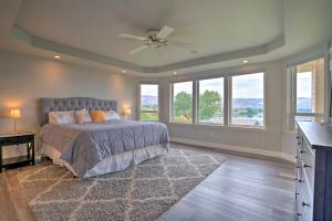 a bedroom with a bed with a ceiling fan and windows at Manson Villa with Hot Tub about 1 Mi to Wineries! in Manson