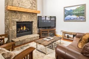 a living room with a fireplace and a tv at Lone Peak Townhome 5 in Big Sky