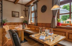 プリーン・アム・キームゼーにあるHotel Luitpold am Seeの木製のテーブルと椅子、窓のあるレストラン