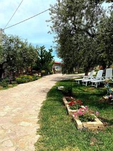 a path with chairs and flowers in a park at FATTORIA ROVELLO in San Paolo di Civitate