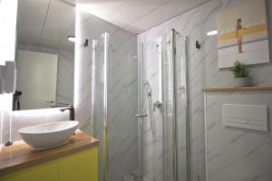 a bathroom with a glass shower and a sink at 1926 Designed ApartHotel in Haifa