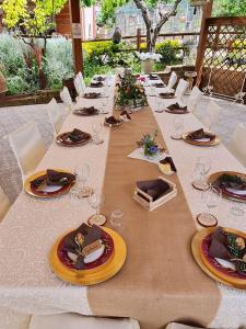 una mesa larga con platos y copas de vino. en FATTORIA ROVELLO en San Paolo di Civitate